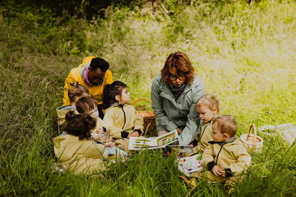 enfants et accompagnatrices dehors dans l herbe