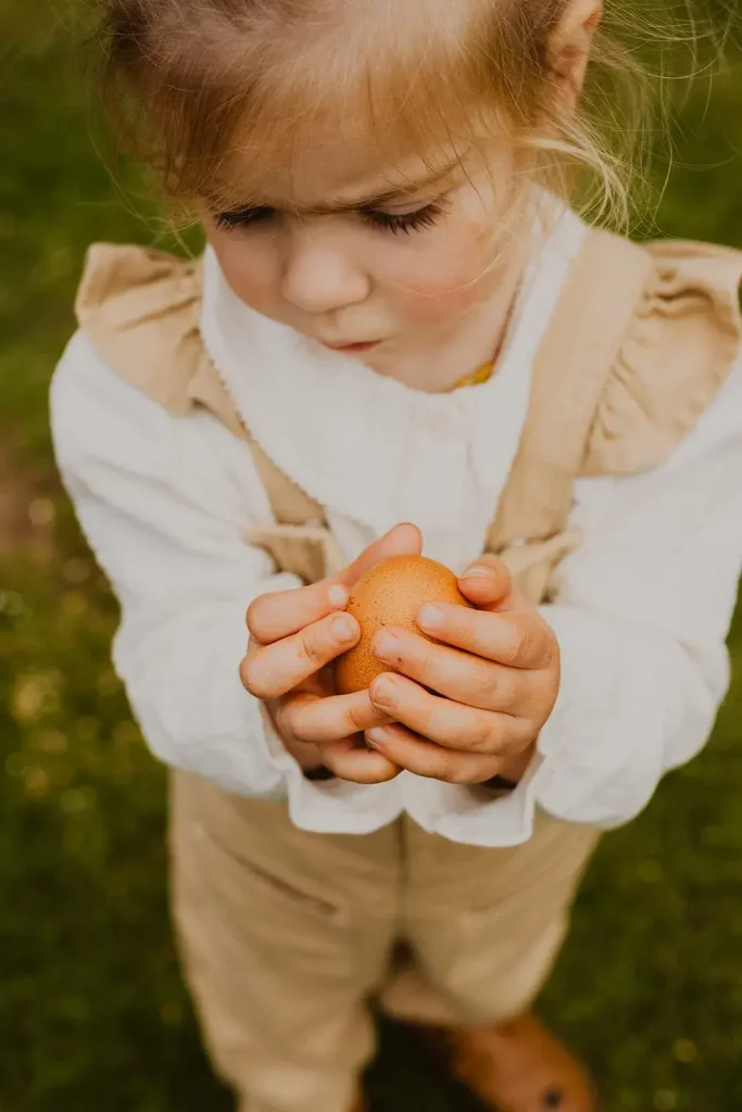 enfant avec un oeuf de poule