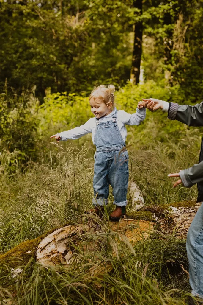 enfant jouant sur un tronc d arbre