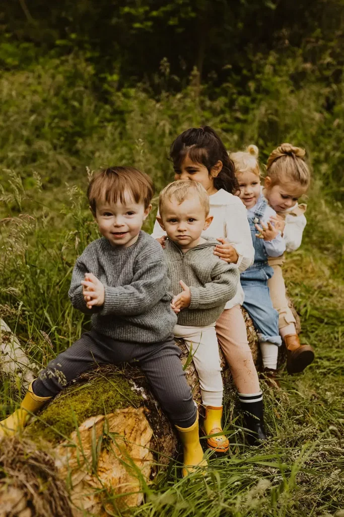 groupe d enfant de la crch tous assis sr un tronc d arbre